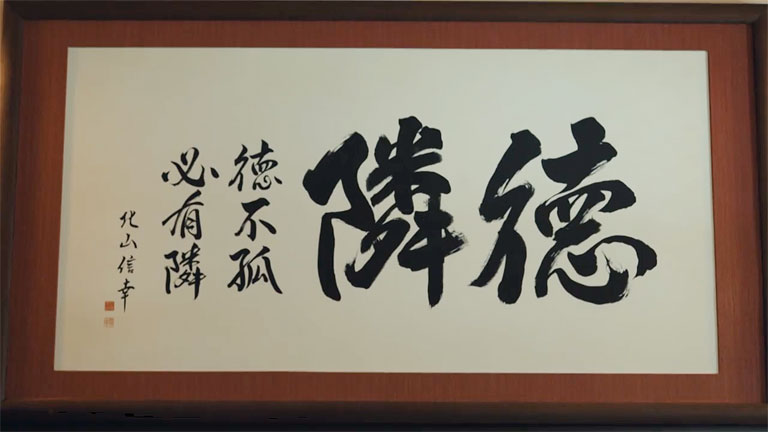 隣徳学園の理事長室に飾られた「隣徳」の書